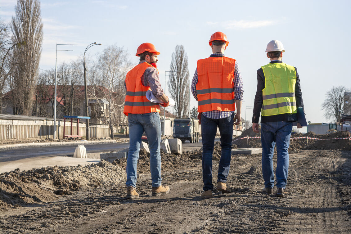 Team walking on a budling site in hi-vis jackets.